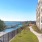 grass and walkway next to a building and a body of water